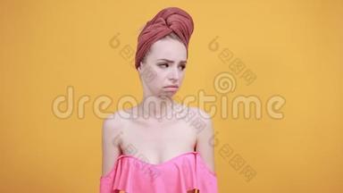 年轻<strong>女孩</strong>头上的毛巾被隔离的橙色背景显示了情绪